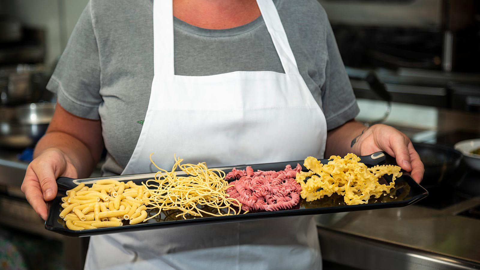 la cuoca del ristorante Seilbahn tiene in mano un plateau con vari tipi di pasta fatta in casa